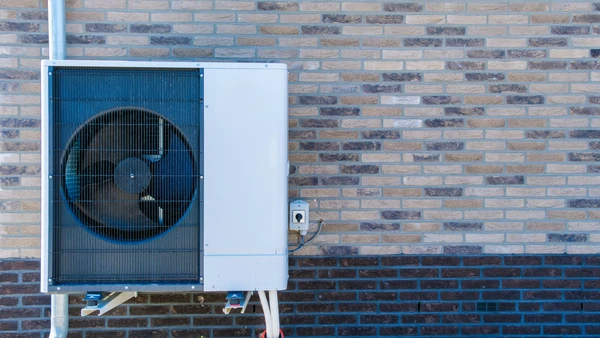 Façade extérieure d'habitation moderne avec pompe à chaleur air-eau installée
